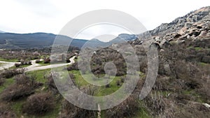 Boulders expanse at the foots of mountain range. Shot. Aerial view of a wild valley covered by stones, greenery and