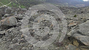 Boulders at foot of mountain. Shot. Drone view of extreme flight over boulders and rocks on mountain slopes. Natural