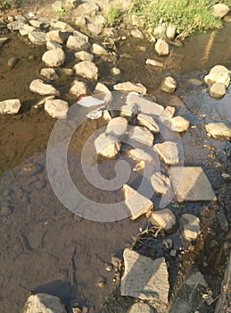 Boulders leading to the other side of river. Water passes through blunders