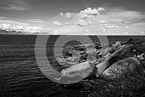 Boulders in the ocean with view across bay.