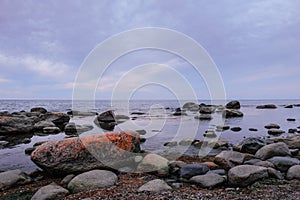 Boulders on a sea shore. Wild rocky seashore on a cloudy day. Fabulous seascape