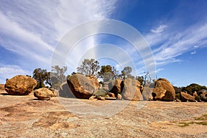 Boulders and trees on the top of the Wave Rock formation in Hyden, Western Australia with blue sky