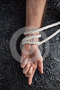 Bound male hand on black background