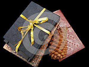 Bound notebook in leather and tied with a gold ribbon