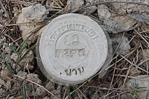 Boundary mark stone of Thailand Department of Lands on ground.