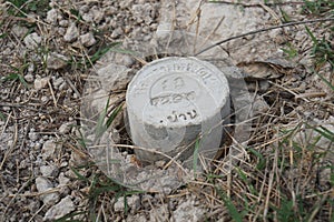 Boundary mark stone of Thailand Department of Lands on ground.