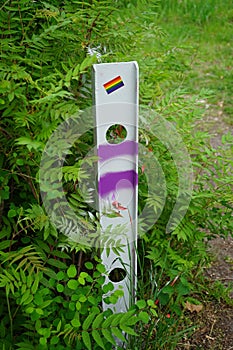 Boundary post on the road with the flag of the LGBT community. Berlin, Germany