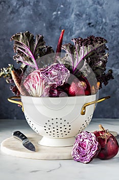 A bouquet arrangement of red and purple vegetables in a vintage colander.