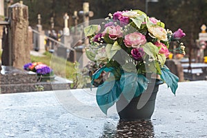 Bouquet of artificial flowers on a tombstone