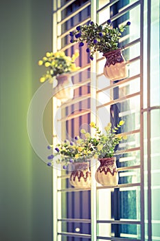 Bouquet of artificial flowers on vase at the window,