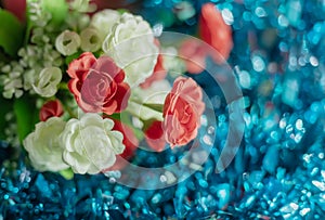 Bouquet of artificial rose flowers on blue background. Close up