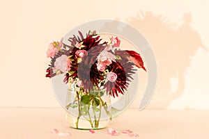 Bouquet of autumn flowers in a green glass pitcher