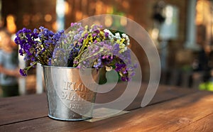 Bouquet of autumn flowers in vintage vase on wooden table in garden. Home decor in rustic style. Mother`s Day. Fresh Field summer