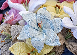 bouquet of beautiful hand crafted crochet flowers. blue, yellow, pink poinsettia style flowers