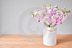 Bouquet of Beautiful lilac mattiola. Spring flowers in vase on wooden table. Flowers delivery.