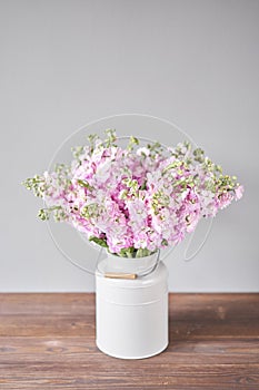 Bouquet of Beautiful lilac mattiola. Spring flowers in vase on wooden table. Flowers delivery.