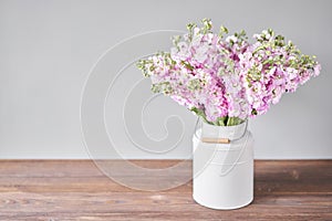 Bouquet of Beautiful lilac mattiola. Spring flowers in vase on wooden table. Flowers delivery.