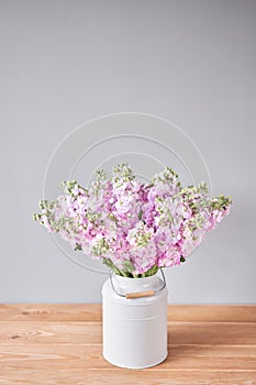 Bouquet of Beautiful lilac mattiola. Spring flowers in vase on wooden table. Flowers delivery. photo