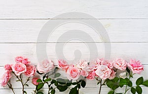 Bouquet of beautiful pink roses on white wooden background.Top view.Copy space