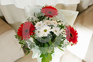 A bouquet of beautiful red gerberas and white chrysanthemums in a vase