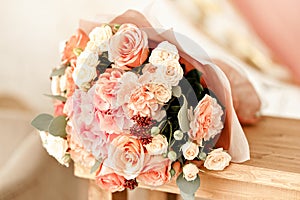 Bouquet of beautiful roses on a beige wooden table