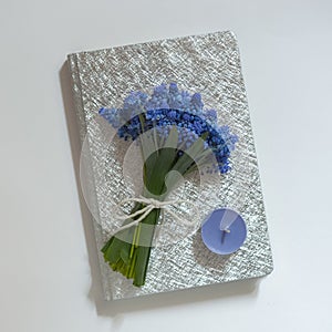 Bouquet of blue flowers on silver book