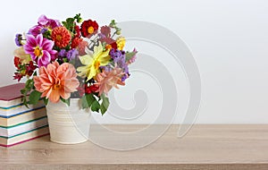 Bouquet of bright dahlias and a stack of textbooks