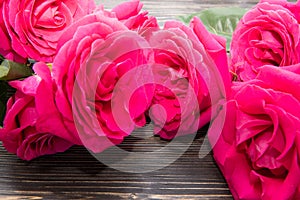A bouquet of bright roses lying on wooden background