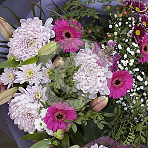 The Bouquet of chrysanthemums, gerberas, chamomiles in paper packing