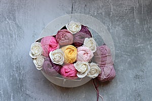 Bouquet of colorful cotton balls in a box on a gray background with copy space. Arts and crafts concept.