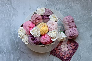Bouquet of colorful cotton balls in a box on a gray background with copy space. Arts and crafts concept.