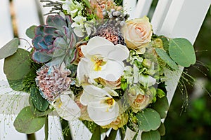 A bouquet of colorful flowers lies on a white bench.