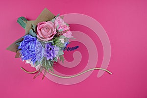 A bouquet of colorful paper flowers on a magenta background as a backdrop for a postcard, invitation letter and etc