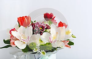 Bouquet of colorful spring flowers on white background with copy space. Bouquet of tulips, orchids, chrysanthemums flowers for