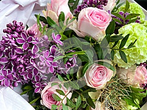 Bouquet with colorful spring-summer flowers. Pink and cream roses, white-green snowball, unusual purple lilac with white edges on