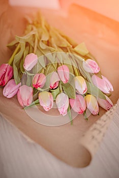 A bouquet of colorful spring tulips wrapped in a craft paper