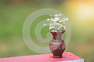 Bouquet of colorful wild wild flowers in a broken clay pot laid on the grass