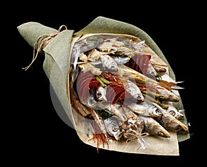 Bouquet consisting of dried fish, chips, pistachios and snacks on a black background as a gift to her husband