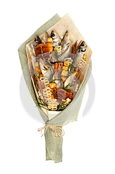 Bouquet consisting of salted stockfish of different breeds, slices of dried squid and other fish on a white background