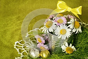 Bouquet of daisies in a metal bucket and shocolate eggs