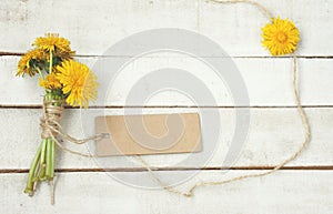 Bouquet of dandelions tied with rope, paper tag