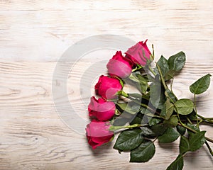 Bouquet of dark red roses on wood table background. Refinement of flowers.