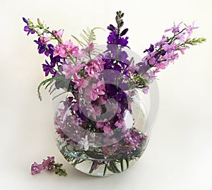 Bouquet of delphinium, chamomile and daylily. Flowers in a bouquet of country style in a glass vase.