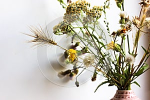 Bouquet of different wildflowers in small vase Flowers in cozy home interior. photo