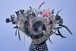 Bouquet of dried flowers in a black vase on a white background prepared for a wedding