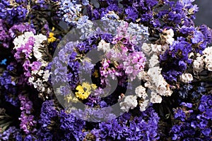 Bouquet of dried wild flowers on a black texture background of vintage wooden planks top view horizontal