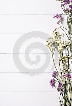 Bouquet of dried wild flowers on a white background of vintage wooden planks top view horizontal, mockup concept