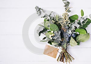 Bouquet of dried wild flowers on white table background with natural wood vintage planks wooden texture top view horizontal