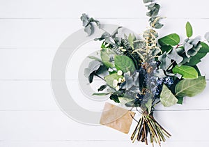 Bouquet of dried wild flowers on white table background  with natural wood vintage planks wooden texture top view horizontal