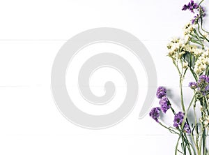 Bouquet of dried wild flowers on white table background  with natural wood vintage planks wooden texture top view horizontal, empt